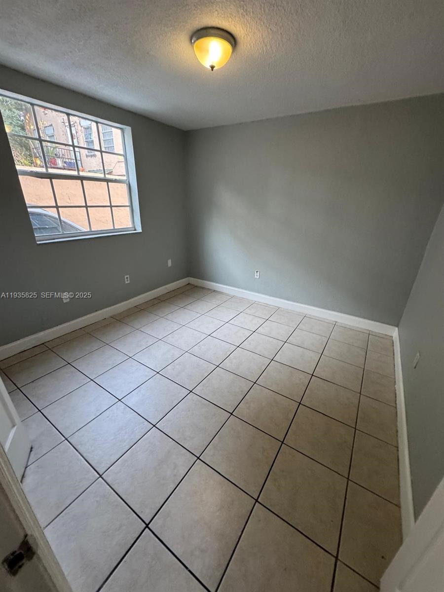 652 Northwest 3rd Street, Unit 104 Miami, FL 33128 - Photo 5 of 15 an empty room with windows