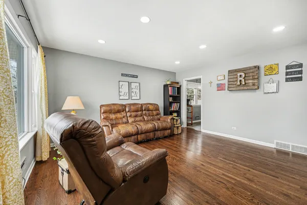a living room with furniture and a wooden floor