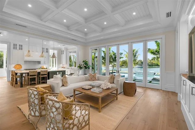 a living room with furniture large windows and wooden floor