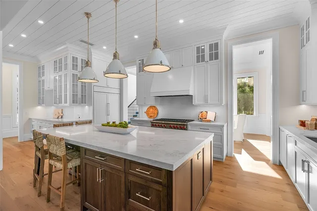 a kitchen with a stove a sink a refrigerator and chairs