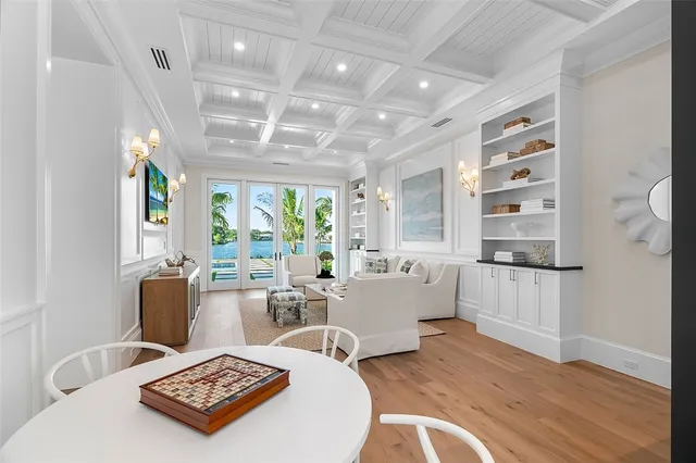 a living room with furniture a large window and wooden floor