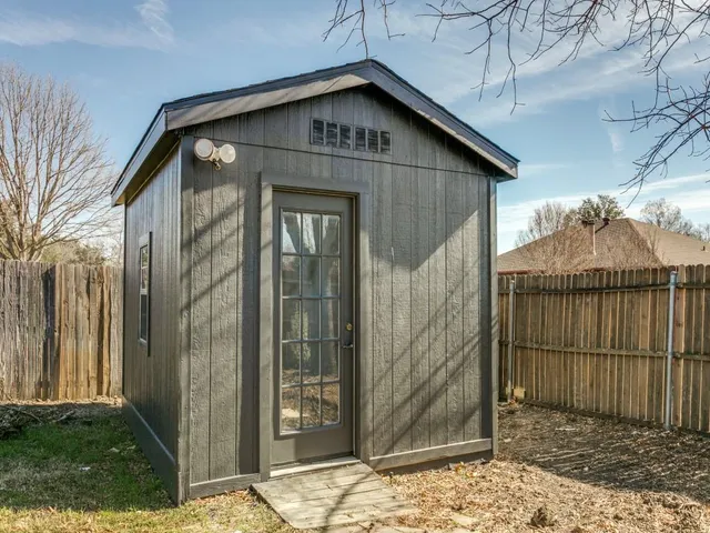 a view of a wooden house with a small yard