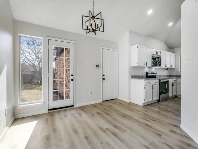 a view of kitchen with granite countertop cabinets and window