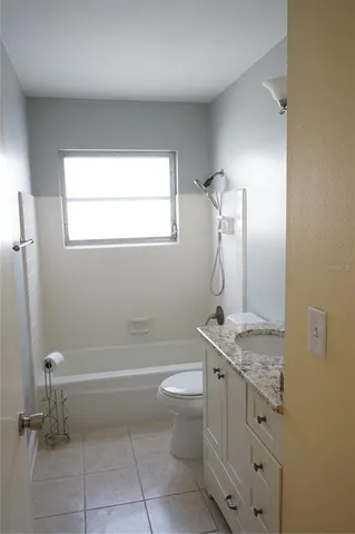 a bathroom with a granite countertop sink a toilet and a mirror
