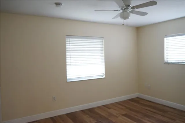 en empty room with a window and wooden floor