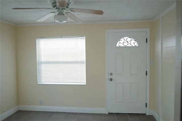 an empty room with windows and fan