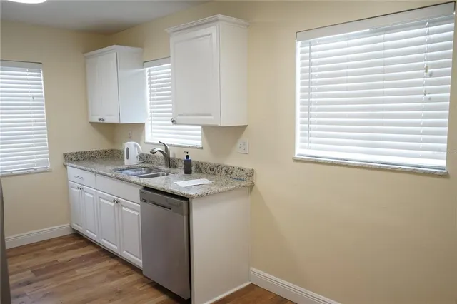 a kitchen with a sink cabinets and a window