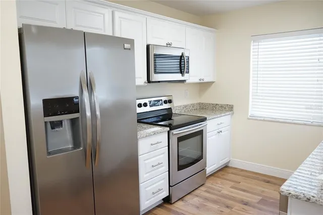 a kitchen with stainless steel appliances granite countertop a refrigerator and a stove