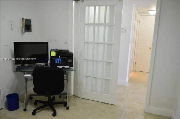 a view of a workspace with furniture and a window