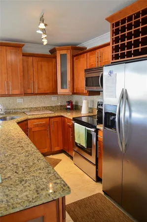 a kitchen with stainless steel appliances granite countertop a sink window and refrigerator