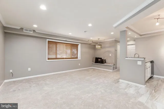 an empty room with a kitchen and a window