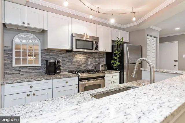 a kitchen with stainless steel appliances kitchen island granite countertop a stove sink and microwave