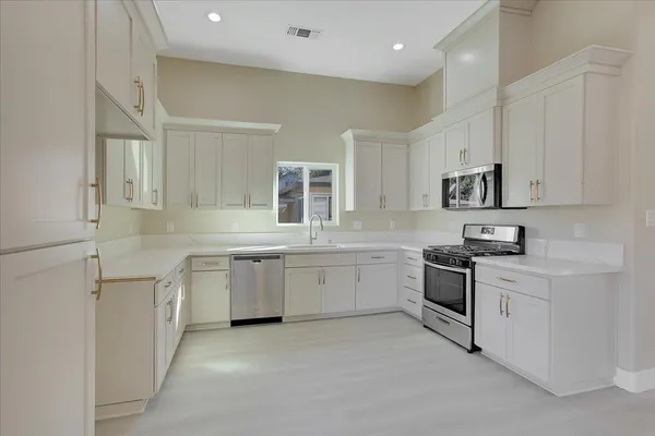 a kitchen with granite countertop white cabinets and white appliances