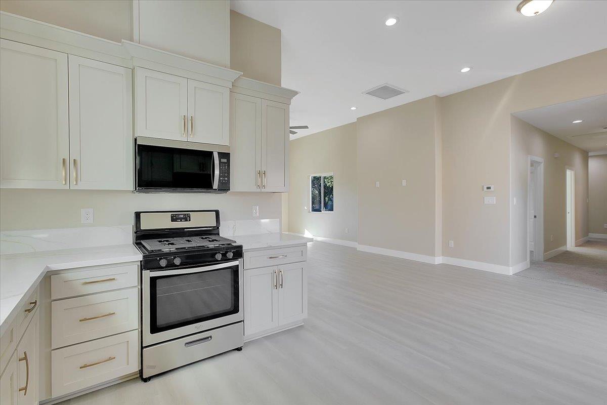 130 Fremont Street Colusa, CA 95932 - Photo 12 of 39 a kitchen with stainless steel appliances white cabinets and a stove top oven