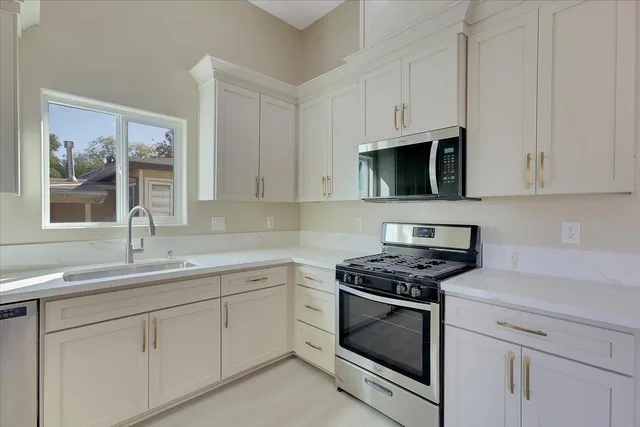 a kitchen with white cabinets and white appliances