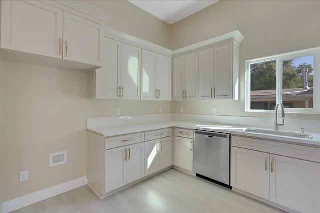 a kitchen with white cabinets and a sink