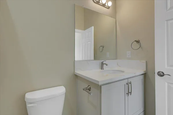 a bathroom with a toilet sink and mirror