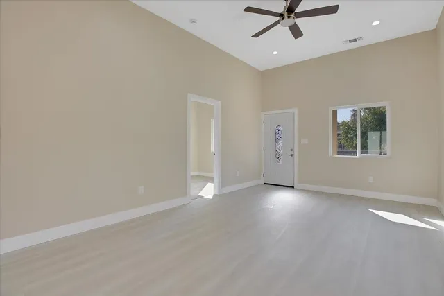 an empty room with fan and windows
