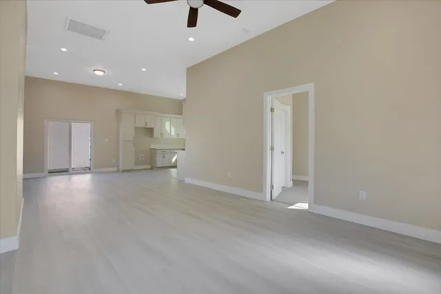 an empty room with wooden floor and natural light