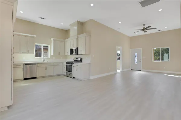 a view of a kitchen with a dishwasher and white cabinets