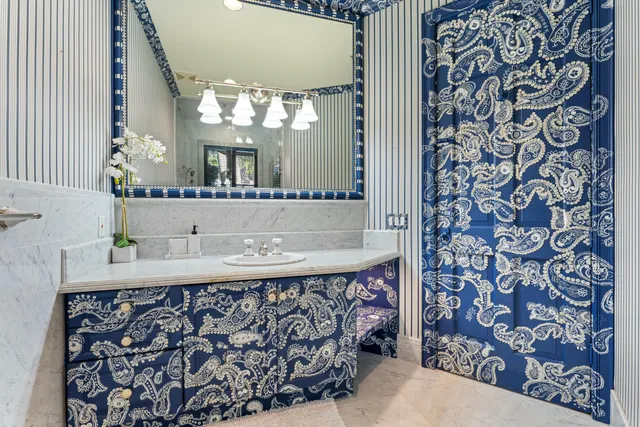 a bathroom with a sink and mirror with bathtub