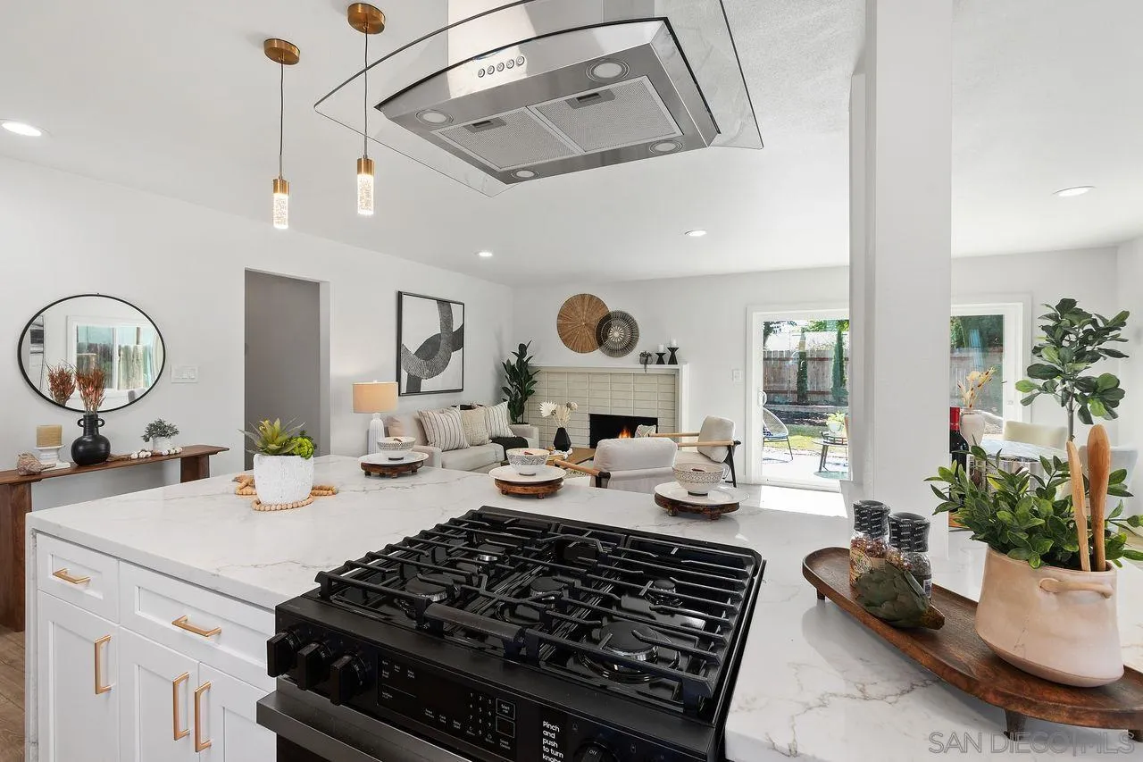 12914 Morene Street Poway, CA 92064 - Photo 10 of 40 a kitchen with a stove a chimney a dining table and chairs