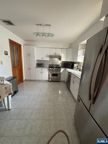 a kitchen with cabinets and wooden floor