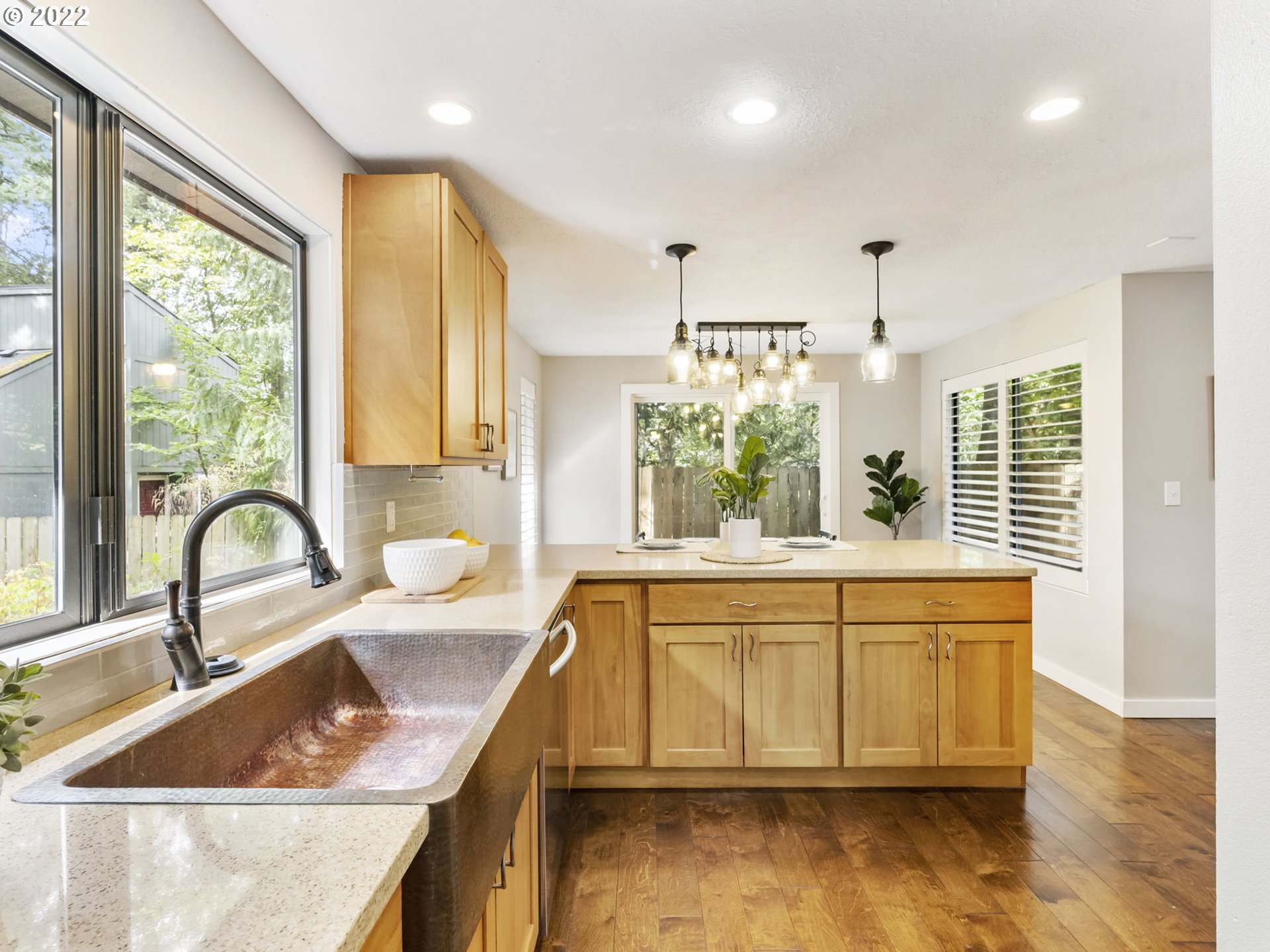 10029 Southwest 52nd Avenue Portland, OR 97219 - Photo 12 of 31 a kitchen with kitchen island a large window cabinets a sink and stainless steel appliances