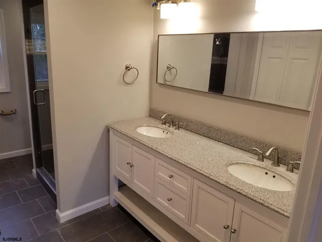 a bathroom with a double vanity sink and mirror