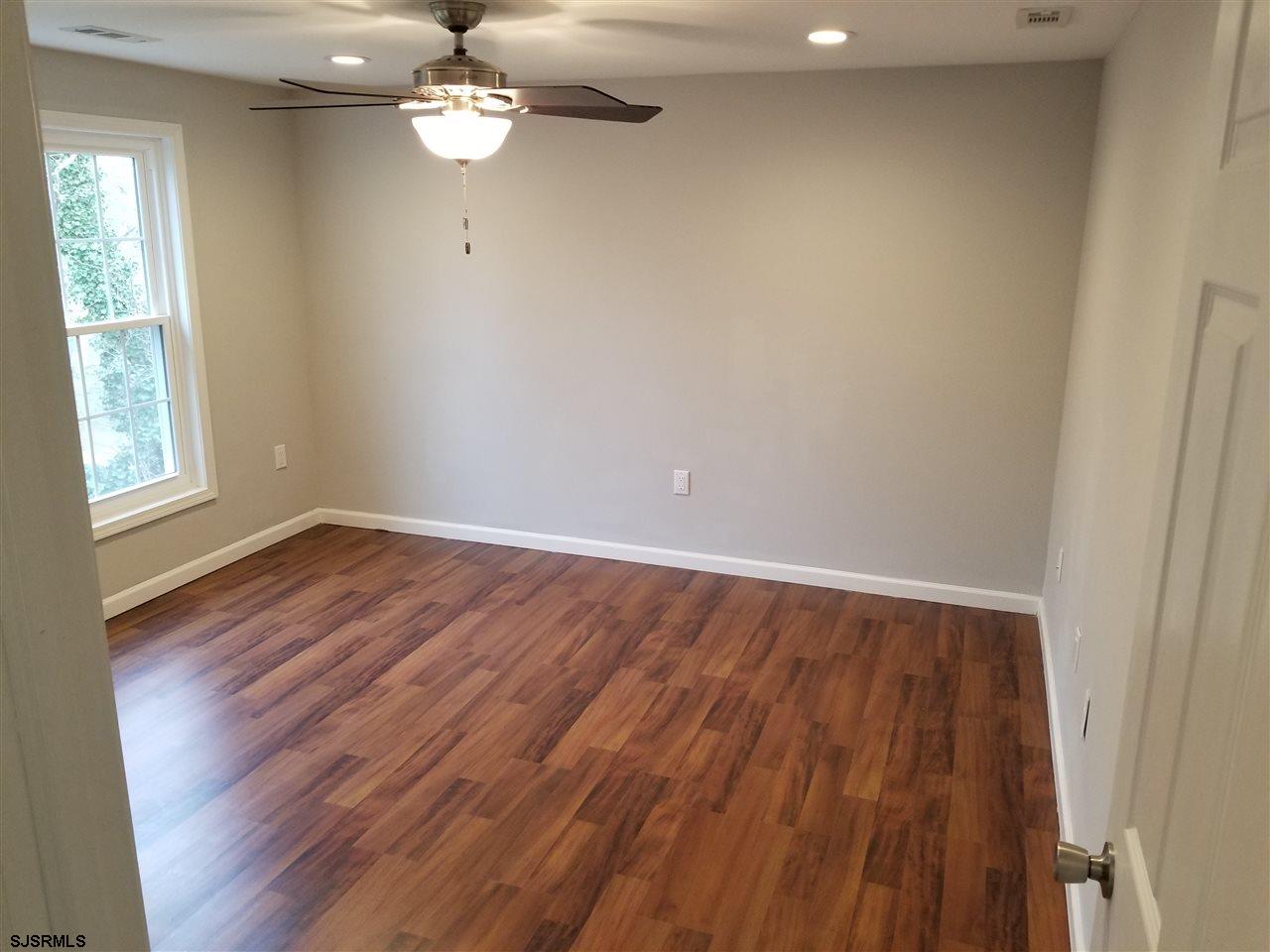 161 East Wyoming Avenue Absecon, NJ 08201 - Photo 17 of 18 wooden floor in an empty room with a window