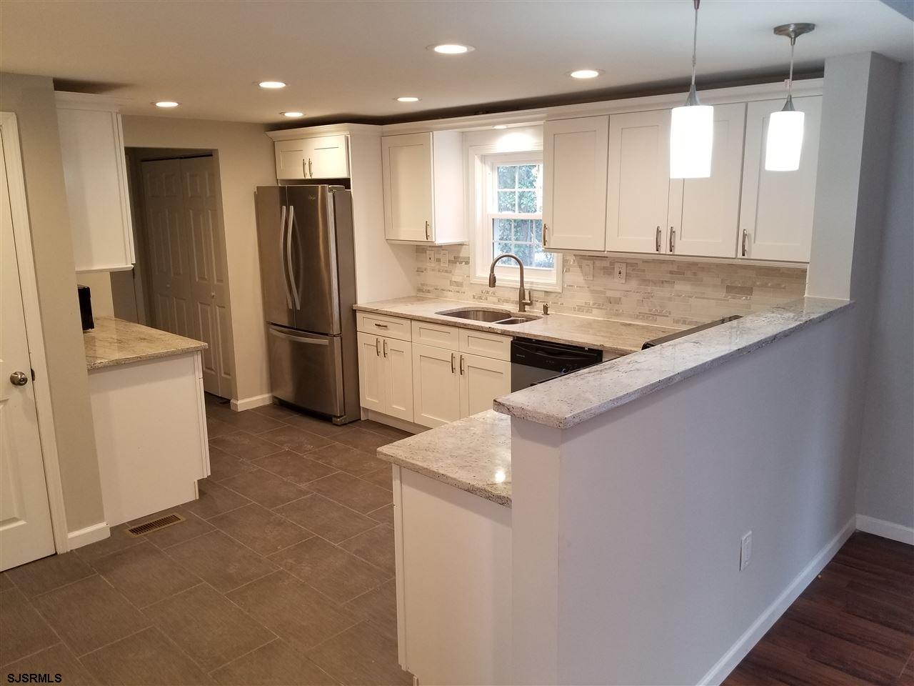 161 East Wyoming Avenue Absecon, NJ 08201 - Photo 6 of 18 a kitchen with stainless steel appliances granite countertop a sink a stove and a refrigerator