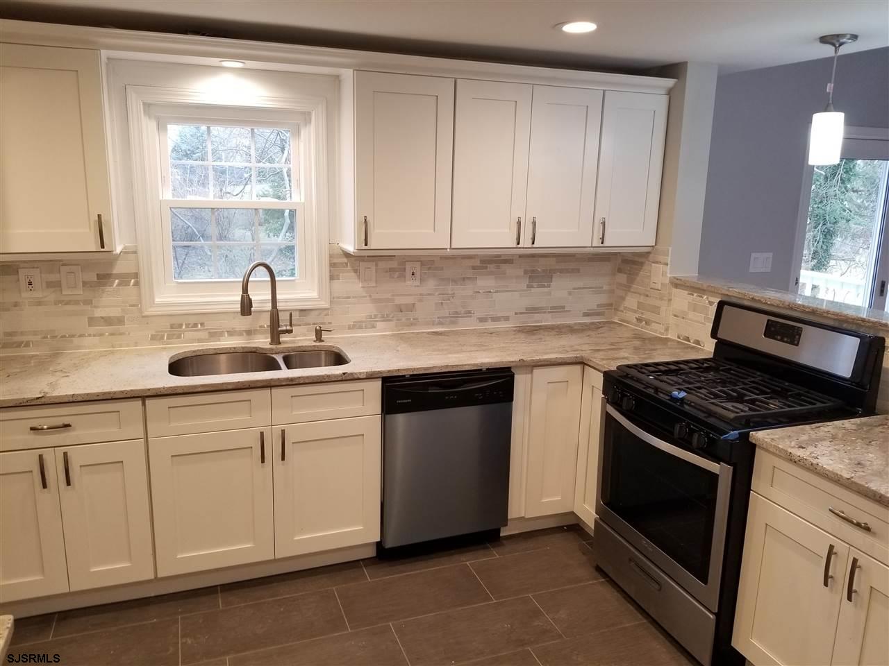 161 East Wyoming Avenue Absecon, NJ 08201 - Photo 7 of 18 a kitchen with granite countertop white cabinets and white appliances