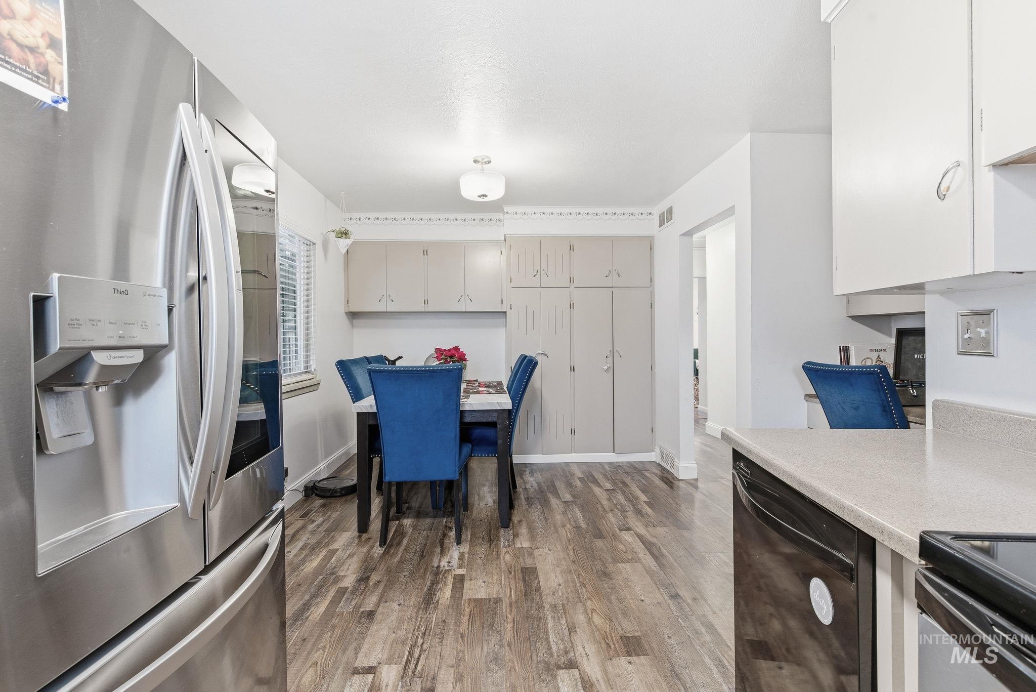 4426 West Clark Street Boise, ID 83705 - Photo 15 of 43 Kitchen with stainless steel refrigerator with ice dispenser, light countertops, dishwasher, and dark wood-style flooring