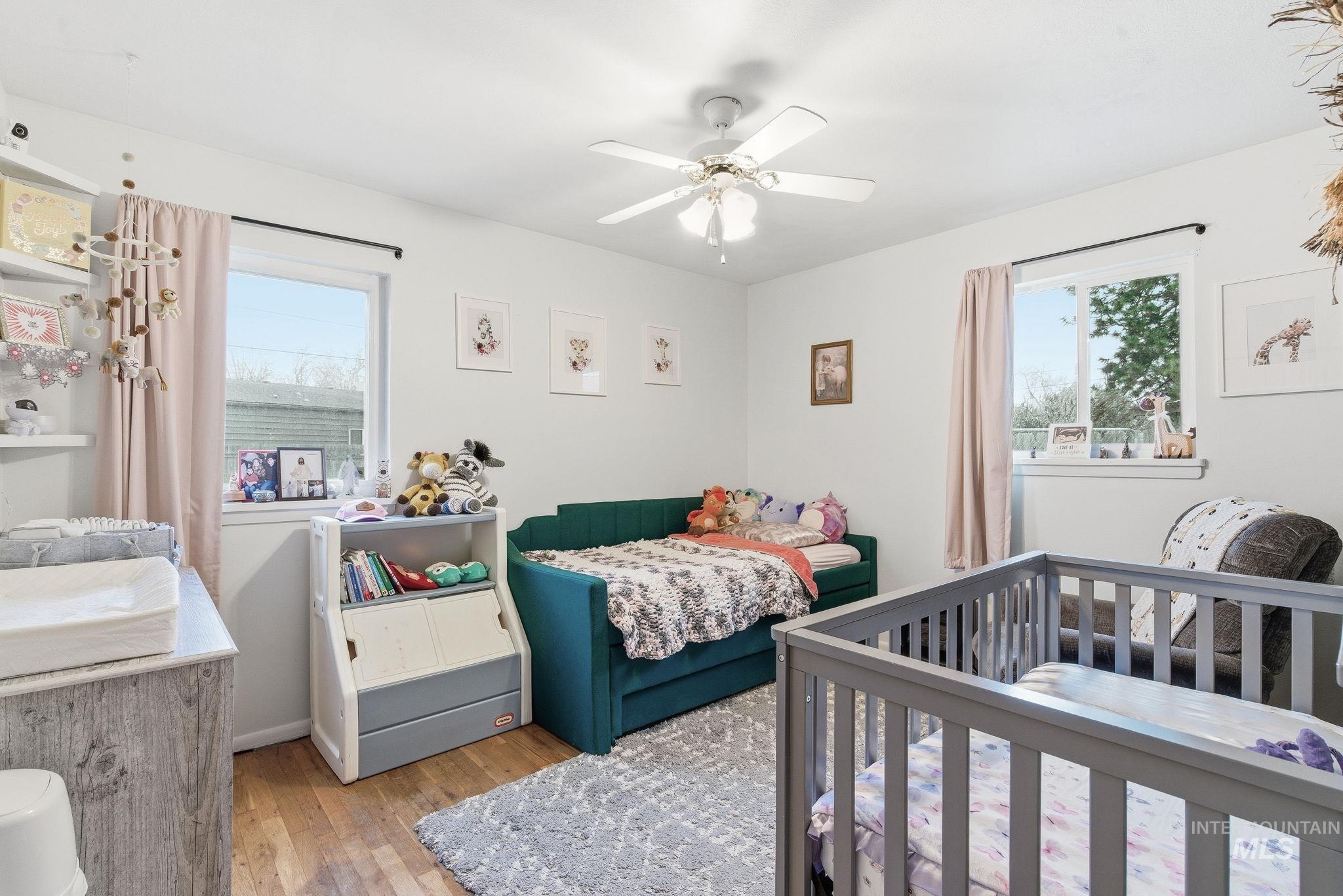 4426 West Clark Street Boise, ID 83705 - Photo 17 of 43 Bedroom with light wood-style floors, a ceiling fan, and multiple windows