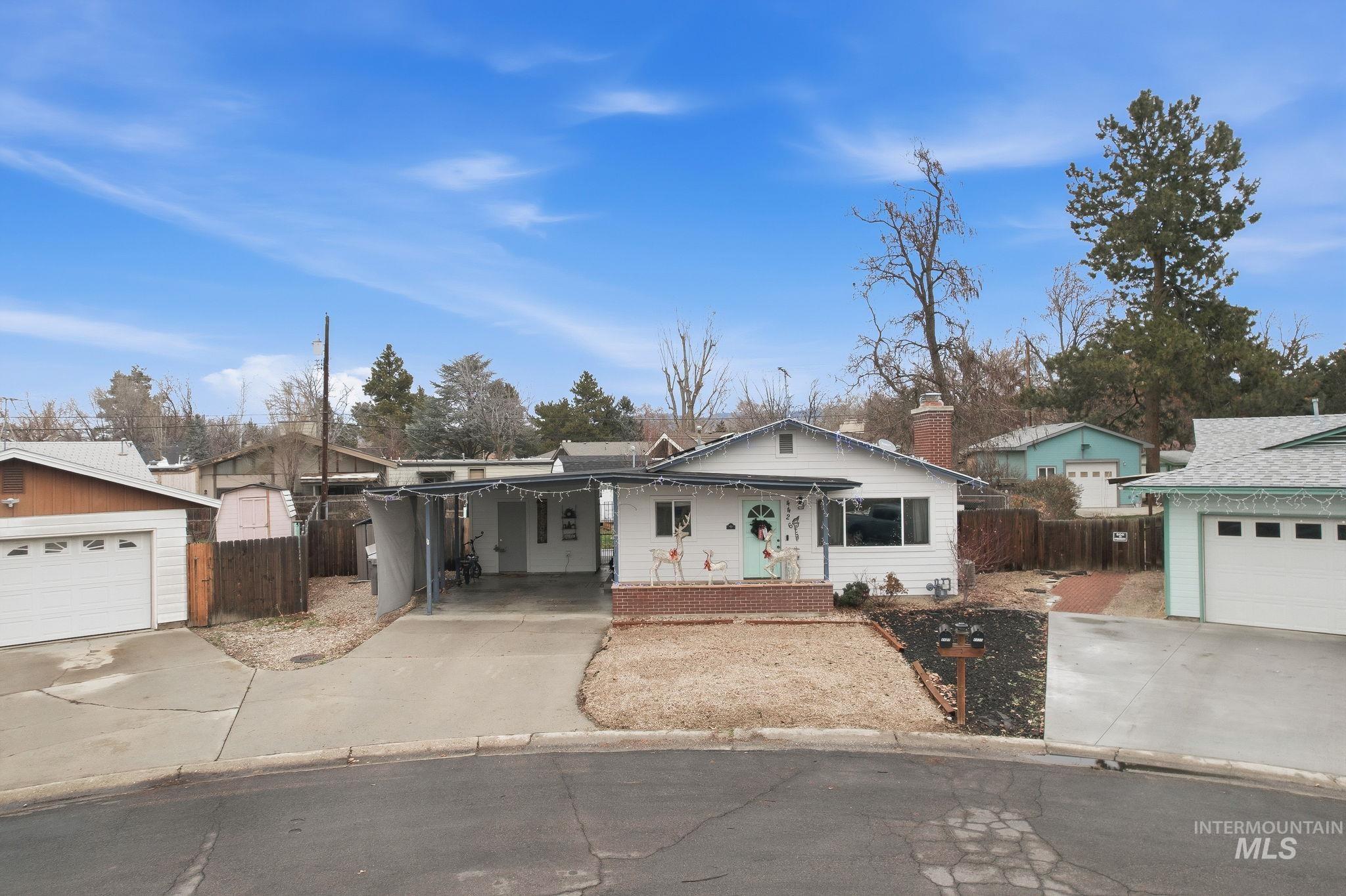 4426 West Clark Street Boise, ID 83705 - Photo 3 of 43 Ranch-style house featuring covered porch, concrete driveway, a garage, and a chimney