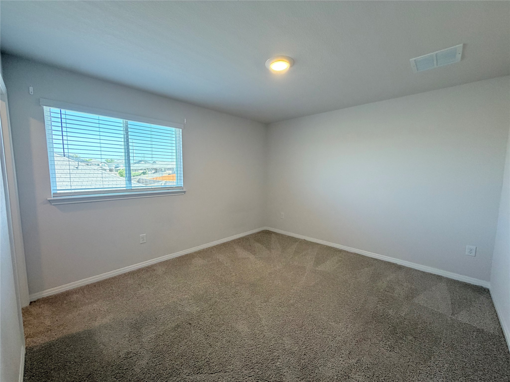 129 Saide Street Georgetown, TX 78626 - Photo 24 of 36 Plush carpeting and a wide window with integrated blinds detail this clean interior.