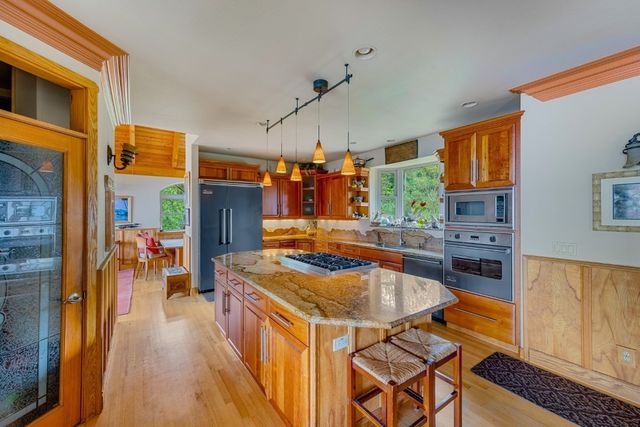 a kitchen with stainless steel appliances granite countertop a stove and a refrigerator