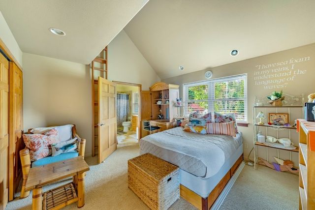 a bedroom with a bed and large windows