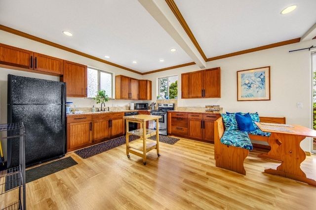 a living room with stainless steel appliances granite countertop furniture a rug kitchen view and a large window