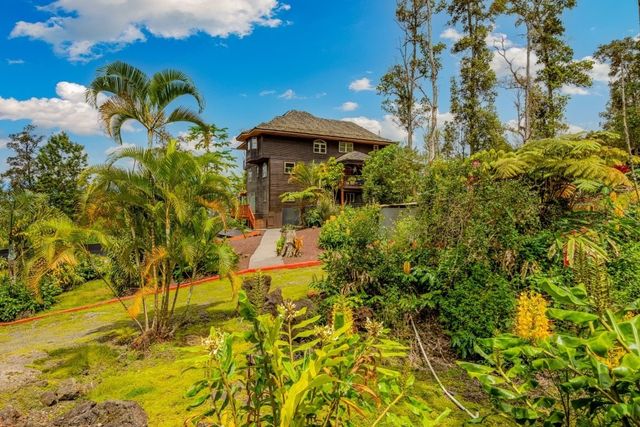 a yellow building with trees in the background