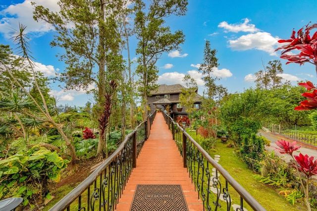 a view of a house with a fountain and potted plants
