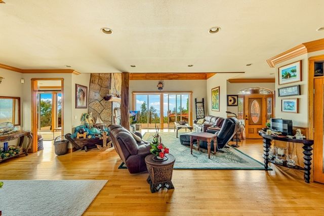 a living room with furniture large window and wooden floor