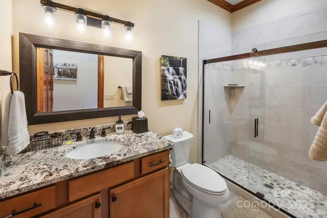 a bathroom with a granite countertop sink toilet and shower