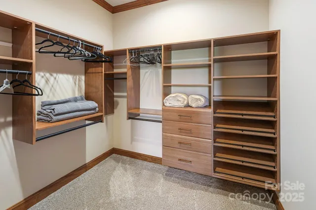 a view of walk in closet with clothes and shoes