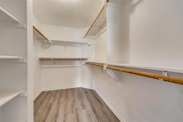 a view of walk in closet with empty racks