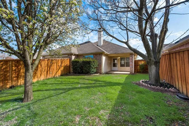 a view of a yard in front of a house with large trees