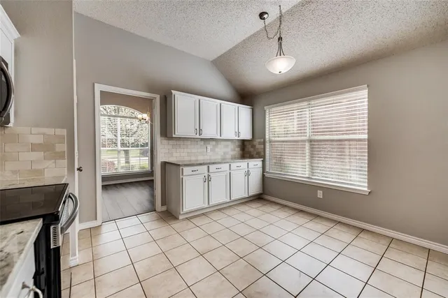 a kitchen with a stove a sink and cabinets