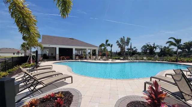 a swimming pool with outdoor seating and barbeque oven