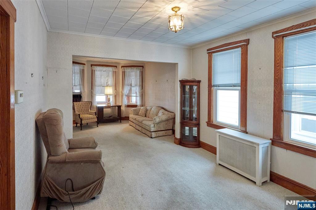235 Dundee Avenue Paterson, NJ 07503 - Photo 6 of 12 a living room with furniture and a chandelier