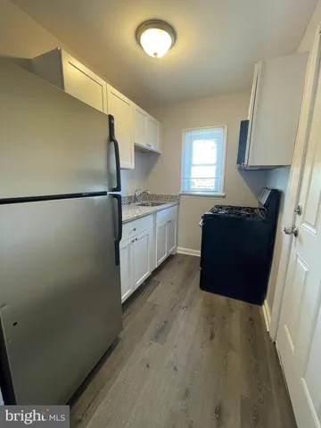 a kitchen with granite countertop a refrigerator a sink and dishwasher